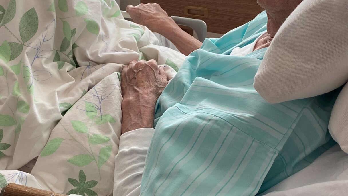 病室のベッドで横たわる高齢者