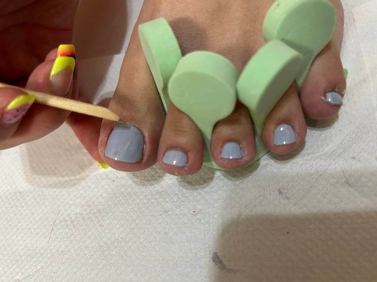 はみ出したジェルをウッドスティックで除去する画像