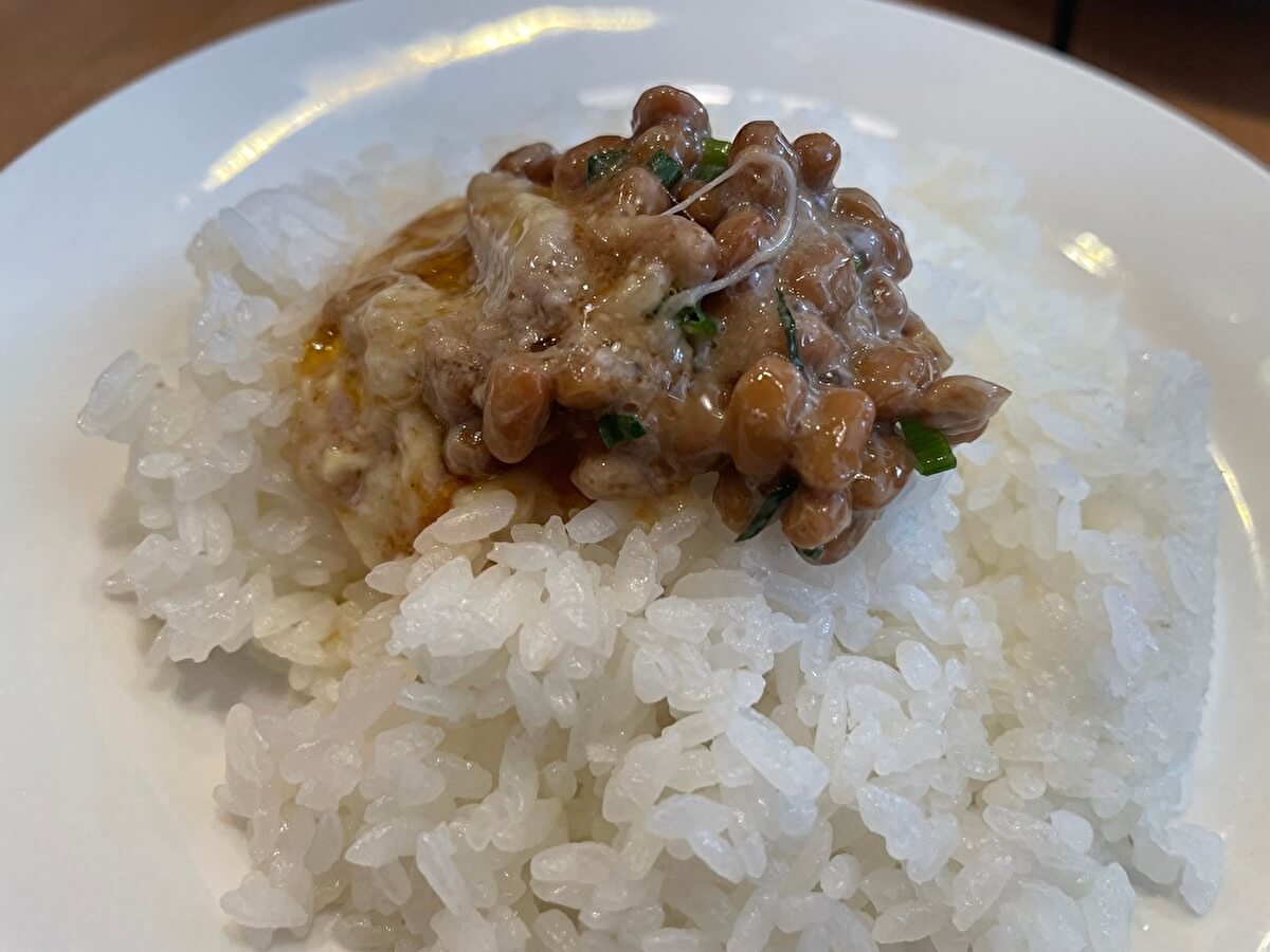 ガスト「チーズINハンバーグ」のチーズと納豆をご飯の上にのせた画像